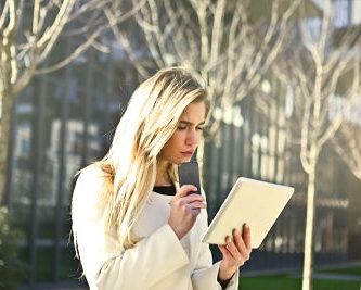 al aire libre una mujer mirando fijamente la pantalla de su tablet