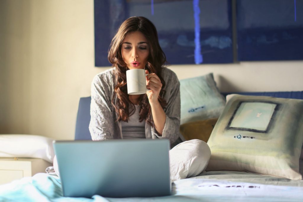 mujer desde su cama utilizando una laptop. negocio necesita una página web